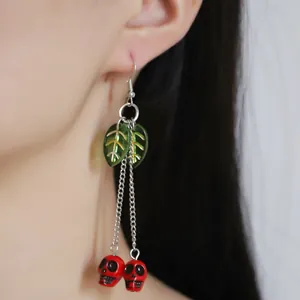 Gothic cherry skull long tassel earrings with green leaf charms on model