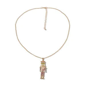 Close-up of pink enamel nutcracker soldier pendant with white pearls on gold chain