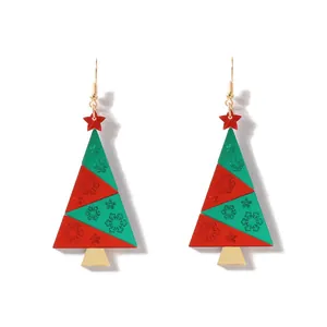 Makroaufnahme von Weihnachtsbaum-Ohrringen mit Schneeflocken und roten Stern-Details