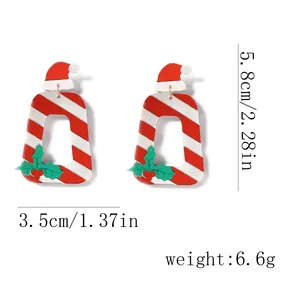 Vue détaillée des boucles d'oreilles bonnet de Noël rayées avec motifs rouges et mesures