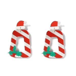 Détail de boucles d'oreilles de Noël avec bonnet de Noël en acrylique et rayures