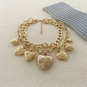 Collar de doble capa dorada con colgantes de corazón vintage y relieve de flores