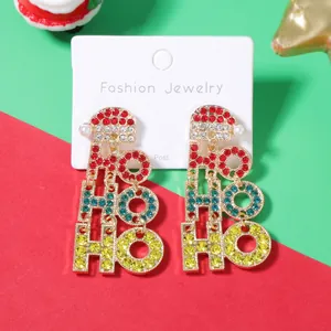 Orecchini pendenti natalizi HO HO HO con strass colorati e perla su sfondo festivo rosso