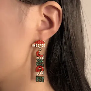Pendientes navideños Jingle con cuentas y gorro de Papá Noel en una modelo