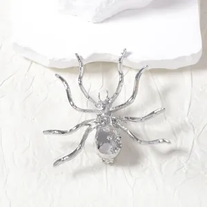 Macro shot of silver spider brooch with rhinestone details and realistic limb joints