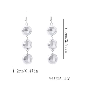 Détail de boucles d'oreilles disco argentées avec dimensions de 7,5 cm par 1,2 cm
