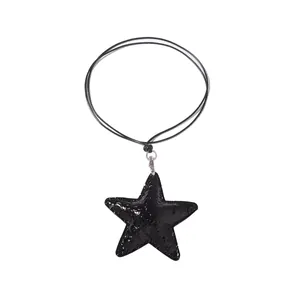 Detail of a black star pendant necklace with glossy cracked leather texture and silver clasp