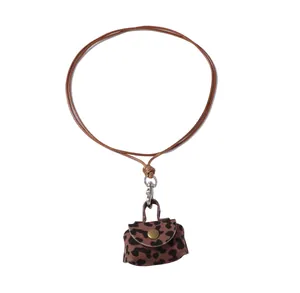 Close-up of leopard print mini pouch pendant with gold button and brown neck cord