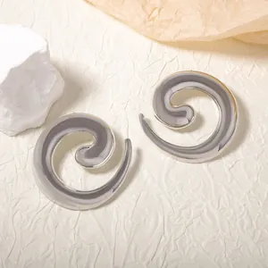 Dettaglio degli orecchini a spirale argentati con finitura metallica lucida