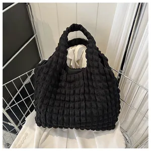 Detail of black pleated tote bag showing premium bubble texture and integrated handle