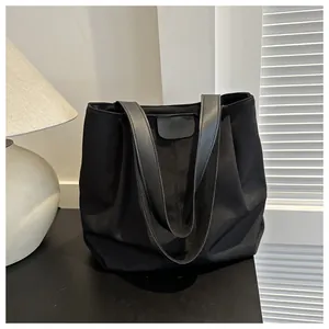 Detalle de la tela de nailon negro de alta calidad y la correa de ecopiel en este bolso tote grande