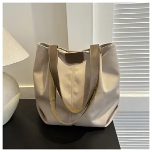 Bolso tote grande de lona con correas de cuero marrón en un ambiente acogedor