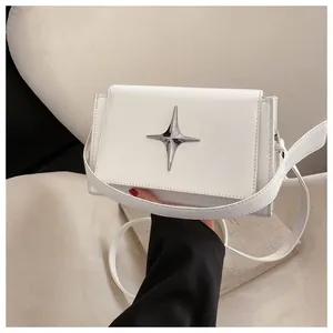 Dettaglio della borsa a tracolla bianca minimalista con stella d'argento e patta