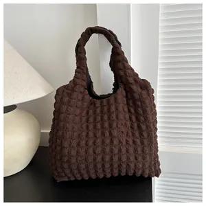 Macro shot of dark coffee tote bag with bubble texture and minimalist lamp background