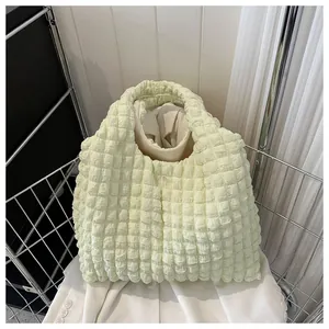 Detail showing the light green popcorn textured fabric of the stylish pleated tote bag
