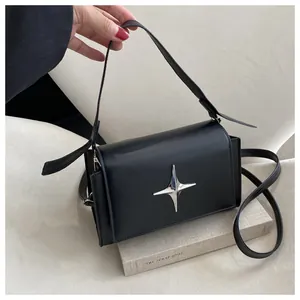 Dettaglio borsa a tracolla in pelle nera con fibbia a stella argentata elegante