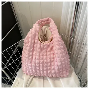 Close-up of pink bubble textured fabric and minimalist interior of the handheld tote bag