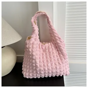 Detail of pink popcorn textured handbag showing pleated 3D fabric and beige lining