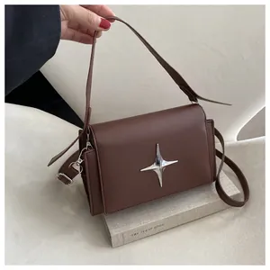 Dettaglio borsa a mano marrone in ecopelle con stella argentata e tracolla rimovibile