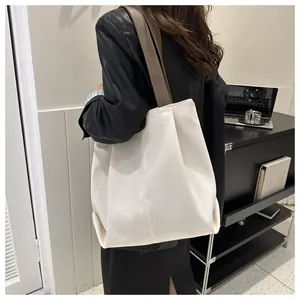 Detalle de un gran bolso tote crema con asas marrón oscuro para el trabajo diario