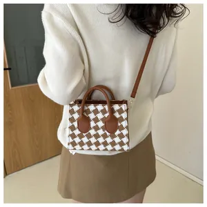 Close-up of mini tweed plaid crossbody bag featuring brown houndstooth pattern and leather handles