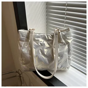 Détail du sac fourre-tout matelassé blanc avec finition brillante et anneaux dorés