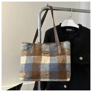 Close-up of the textured plaid fabric and leather handle on the French tote bag