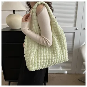 Close-up of light yellow bubble texture tote bag showing spacious interior and shoulder strap