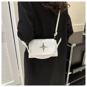 Dettaglio della borsa a tracolla in pelle verniciata bianca con fibbia a stella argento
