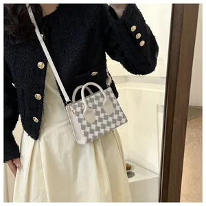 Chic grey houndstooth pattern handbag shown with white leather handle on a model
