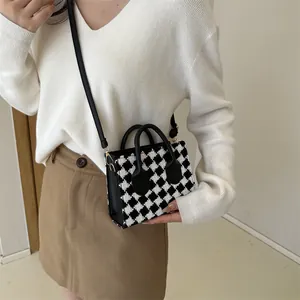 Classic checkered wool mini tote bag with black leather straps shown on a model