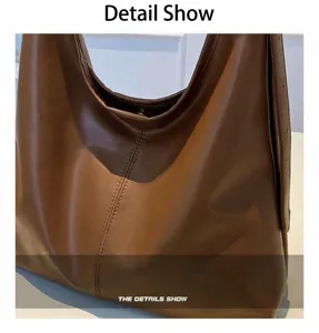 Détail du sac à bandoulière en cuir marron avec couture verticale et fermoir aimanté en métal