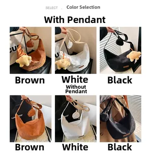 Detail view of corduroy crescent crossbody bags in brown, white, and black with star charms