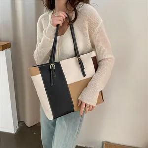 Minimalist color-block PU leather tote bag with adjustable strap worn by a model