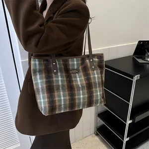 French style plaid tote bag with brown leather straps shown on a model's shoulder