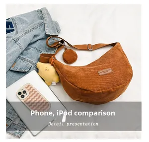 Detailed size comparison of caramel corduroy crescent bag with phone and tablet