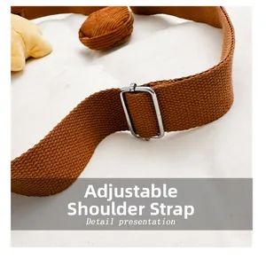 Close-up of brown adjustable corduroy bag strap with metal buckle and small coin pouch