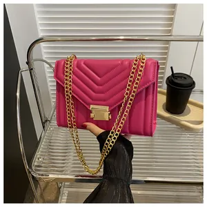 Detailed view of the rose red V-quilted small square bag with golden chain straps