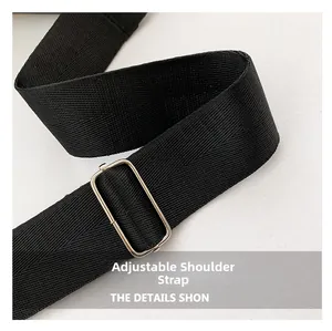 Detalle de la correa ajustable de nailon negro con hebilla de metal plateado para bolso