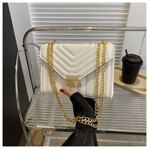 Close-up of white quilted PU leather shoulder bag featuring V-shaped stitching and gold chain