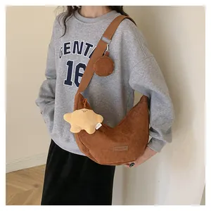 Brown corduroy hobo bag with a plush star charm and round coin purse detail view