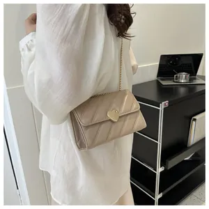 Chic beige quilted small crossbody bag with gold heart clasp and metal chain strap