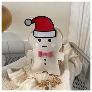Detail of gingerbread man crossbody bag with golden chain on white knitted fabric