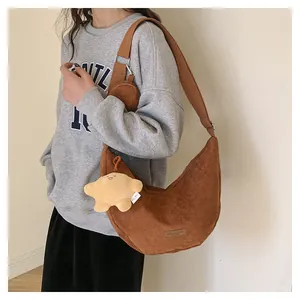 Caramel corduroy hobo bag with mini pouch and star charm on a model in a minimalist setting