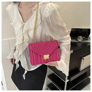 Detail of rose pink quilted leather small crossbody bag with gold chain and square lock