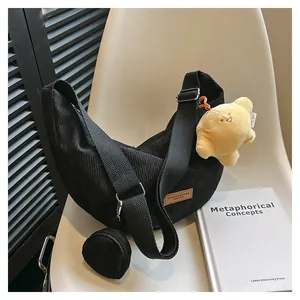 Detail of black corduroy hobo bag with mini pouch and cute yellow plush charm
