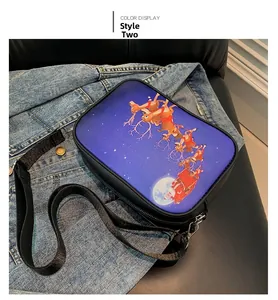 Detalle del bolso bandolera negro con gráficos de Papá Noel sobre una chaqueta vaquera