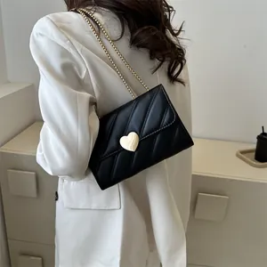 Elegant black quilted crossbody bag with large gold heart lock and metal chain strap