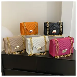 Detailed close-up showing five colors of V-quilted faux leather crossbody bags with gold chains