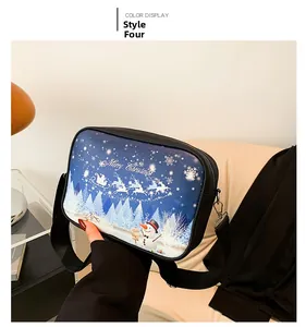Detalle del grafiti navideño en bolso bandolera negro con renos y copos de nieve